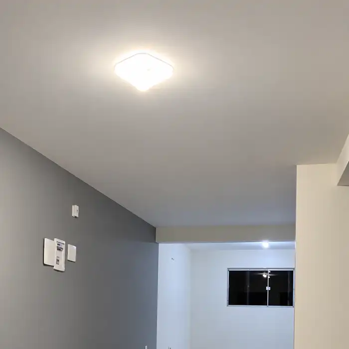 Ambiente residencial com luminária instalada e acesa em serviço realizado pela AR Instalações.